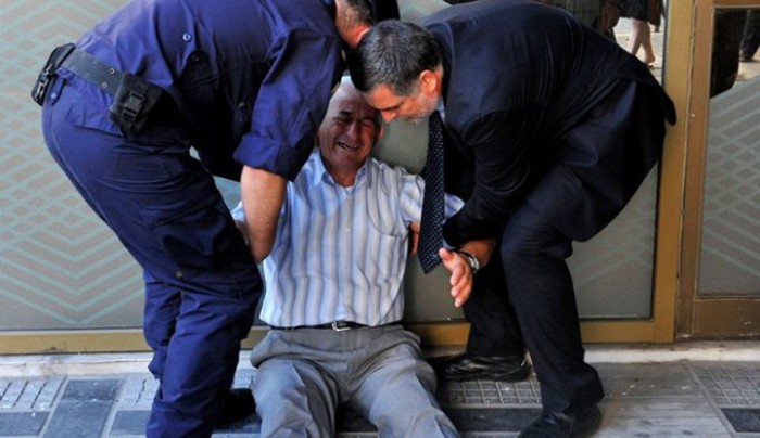  3 Ιουλίου 2015. Ο συνταξιούχος Γιώργος Χατζηφωτιάδης καταρρέει περιμένοντας στην ουρά του ATM στη Θεσσαλονίκη εν μέσω capital controls. Το Γαλλικό Πρακτορείο απαθανάτισε τη στιγμή.