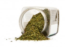 spilled dry basil, against whit ebackground, natural shadow underneath, shallow DOF