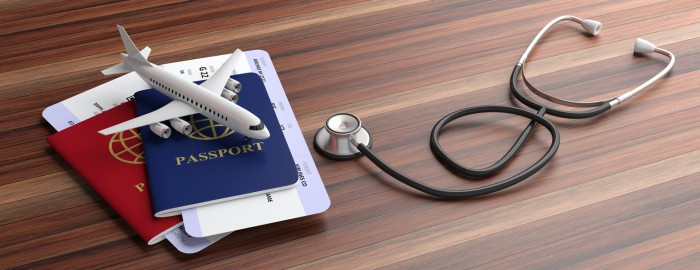 Blue and red passports and medical stethoscope isolated on wooden background. 3d illustration